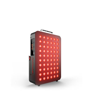 Man using BQ60 red light therapy device at bedside, showcasing red LED panel in use.