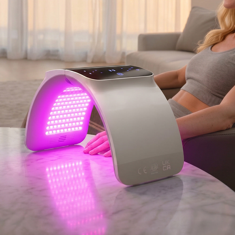 Woman using BestQool 7 Color Photon LED Light Therapy emitting purple light for home hand spa.