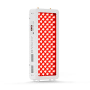 Man reading beside Half-Body Red Light Therapy Pro100 emitting therapeutic red light.